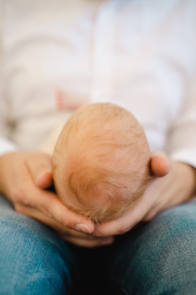 Babykopf in Papas Händen