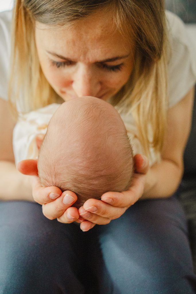 Baby Kopf Mamas Hände emotional